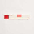 Box of incense sticks with red and beige design on a white background