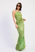 Woman wearing a green evening gown with floral details on a white background