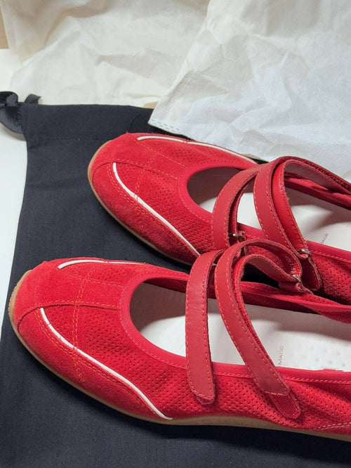 Red shoes with white soles on a white surface