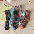 Colorful striped socks on a textured surface with a 'Bag Design' book.