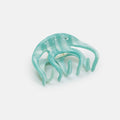 Turquoise hair clip on a light gray background