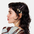 Person with hair styled using decorative hairpins on a plain background