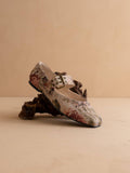 Floral patterned shoe with a buckle on a beige background