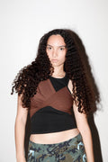 Woman wearing a brown and black top with camouflage pants against a white background