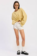 Person wearing a yellow sweater and white shorts on a white background