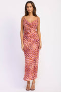 Woman wearing a pink and orange patterned dress on a white background