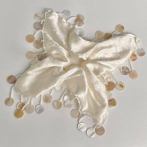 White butterfly with pearl-like embellishments on a light gray background