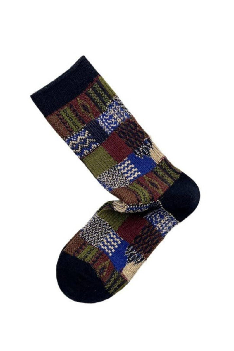 A pair of crew socks with a multicolor patchwork knit pattern featuring navy blue cuffs and toes, displayed on a clean white background.