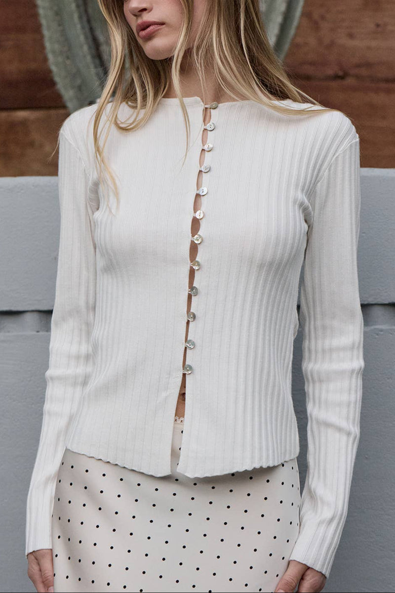Woman wearing a white ribbed cardigan with buttons outdoors