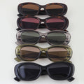 Stack of five pairs of sunglasses with different lens colors on a white background