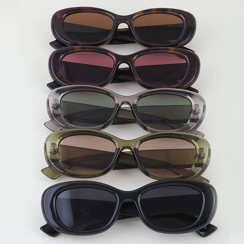 Stack of five pairs of sunglasses with different lens colors on a white background