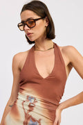 Woman wearing a brown halter top with a plain background