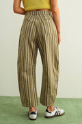 Person wearing striped pants on a green floor with a light background