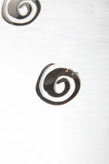 Metallic spiral earrings on a light gray background