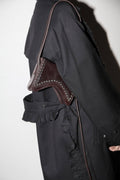 Black coat with brown leather shoulder detail on a white background