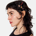 Woman with styled hair featuring decorative hairpins against a white background