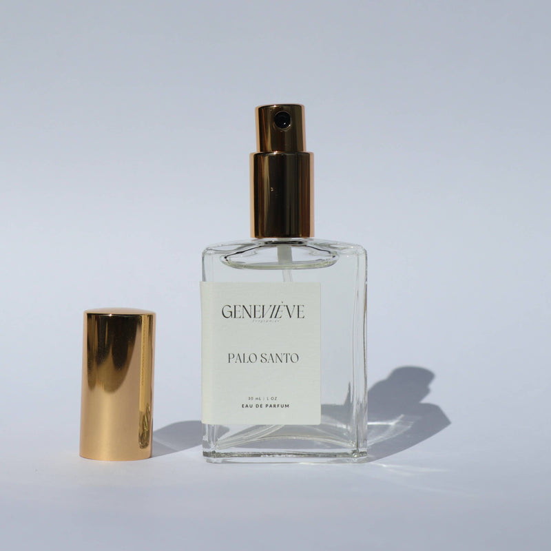 Perfume bottle with gold cap and 'GENEVE' label on a light gray background