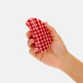 Hand holding a red and white checkered object against a white background