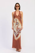 Woman wearing a rust-colored halter top and a long, patterned skirt on a white background