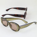 Two pairs of sunglasses with tortoiseshell and green frames on a white background