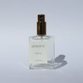 Perfume bottle labeled 'Genevieve Santal' on a light gray background