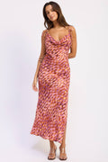 Woman wearing a pink and orange patterned dress on a white background