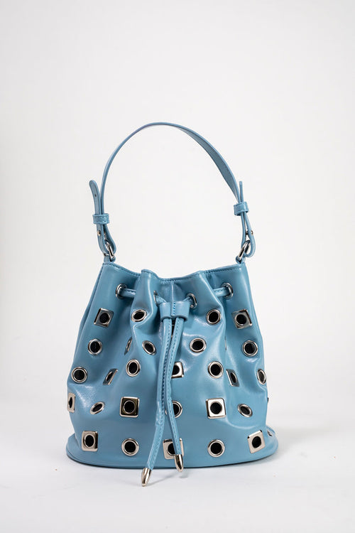 A light blue leather bucket bag with silver-tone metal eyelets and a drawstring closure, photographed against a plain white studio background.