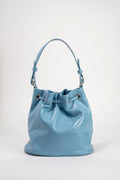 A light blue leather bucket bag with a single shoulder strap and silver-tone hardware, photographed against a plain light gray studio background.
