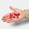 Hand holding three red hair clips with a white background