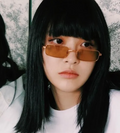 Person wearing sunglasses with a neutral background