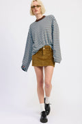 Person wearing a striped sweater, mustard skirt, and black shoes on a white background