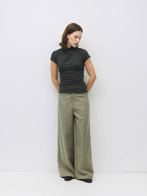 Woman wearing grey slouchy top and wide leg pant.