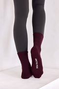 Maroon socks with 'Arctic Fox' branding worn with gray leggings on a white background