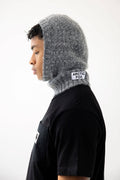 Person wearing a gray knitted balaclava with 'Arctic Fox' branding on a white background