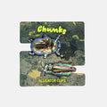 A pair of iridescent alligator-style clips displayed on a printed backing card. The backing card has a dark textured background with two beetle illustrations and yellow text reading 'Chunks' and 'ALLIGATOR CLIPS'.