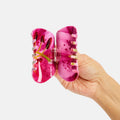 Hand holding pink butterfly shoes with a white background