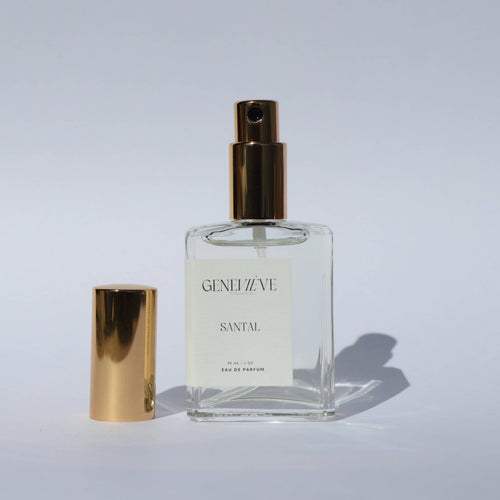 Perfume bottle with gold cap and 'GENIEVE' label on a light gray background