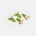 Four green hair clips with pink flowers on a white background