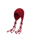 Red knitted hat with tassels on a white background