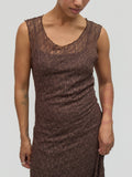 Woman wearing a brown lace dress against a plain background
