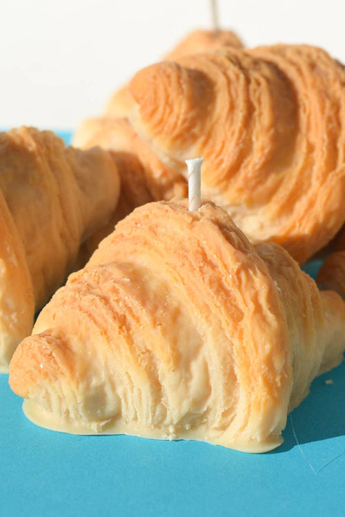 Croissant-shaped candles on a blue surface