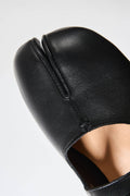 Black leather sandal on a light gray background