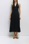 Woman wearing a black polka dot dress against a white background