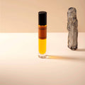 Small bottle of Paraphrase perfume with a wooden stick on a beige background