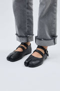 Black shoes worn with gray jeans on a white background