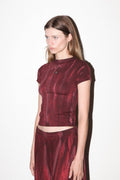 Woman wearing a maroon velvet outfit on a white background