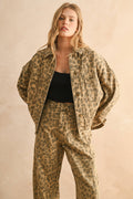 Woman wearing a leopard print jacket and pants on a beige background