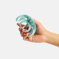 Hand holding a light blue silicone tool against a white background