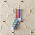 Colorful striped sock on a textured beige surface