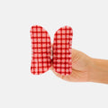 Red and white checkered butterfly-shaped pouch held by a hand on a white background